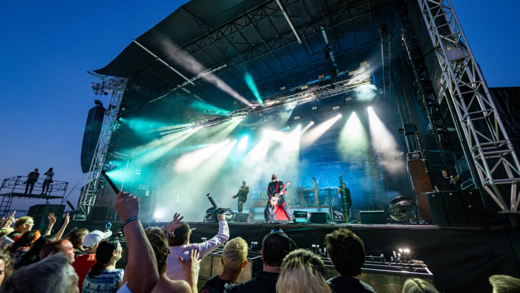 Band optræder på scenen foran et begejstret publikum til koncert på Skive Festival på Strandtangen.