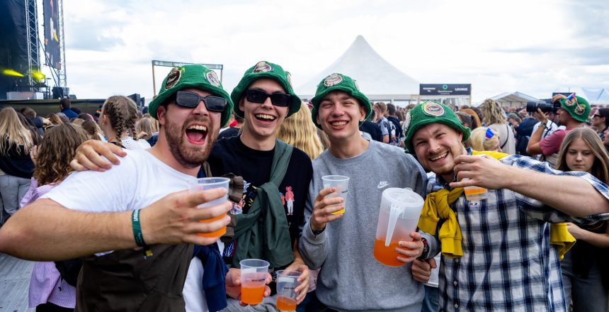 Fire venner med grønne bøllehatte og drinks nyder festivalstemningen på Skive Festival.