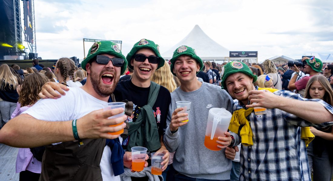 Fire venner med grønne bøllehatte og drinks nyder festivalstemningen på Skive Festival.