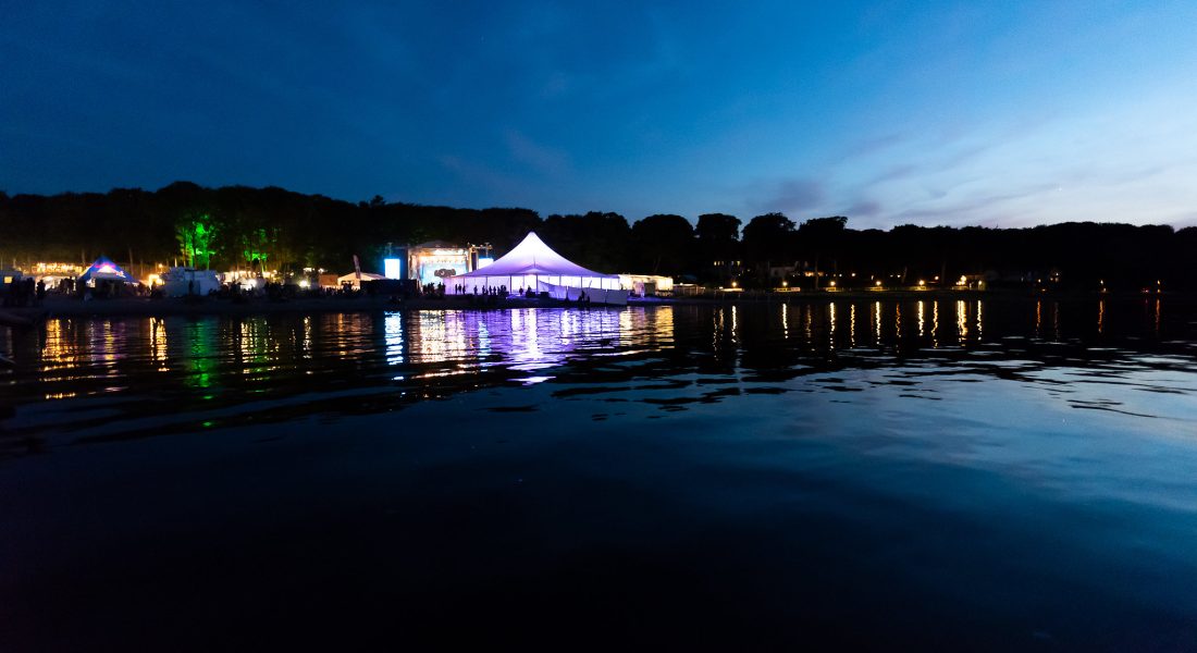 Skive Festival aftenstemning med hvidt telt og lysrefleksioner i vandet ved Strandtangen i Skive, Jylland.