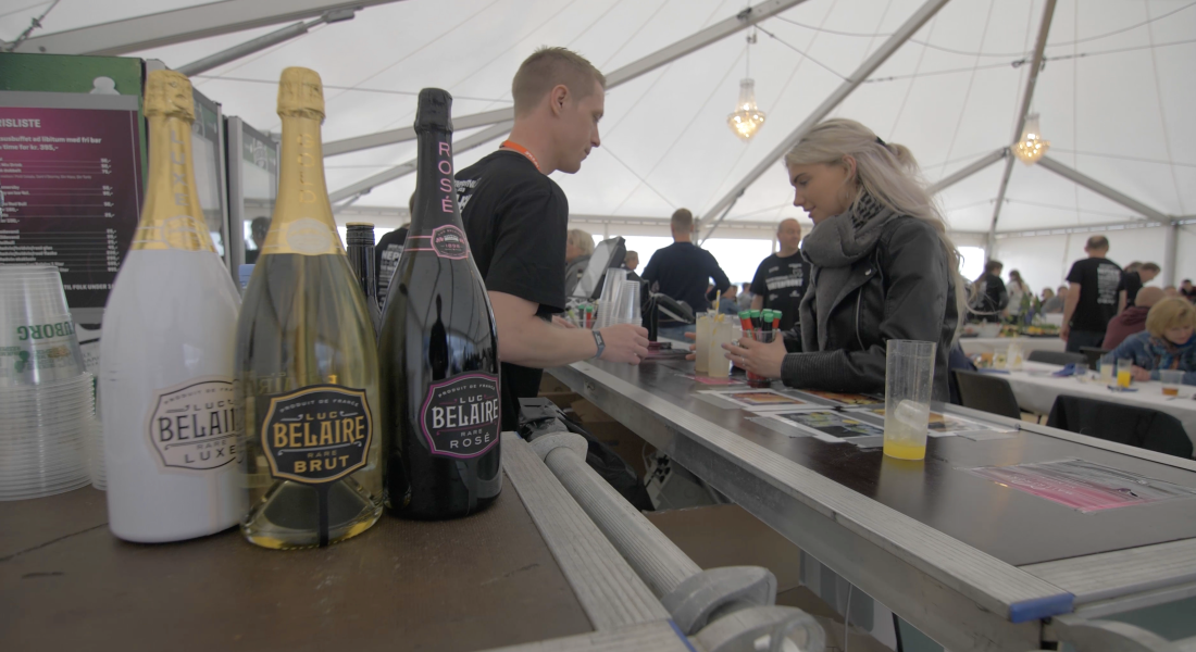 Gæst serveres i Sparekassen Danmark Lounge på Skive Festival med Luc Belaire champagne i forgrunden.