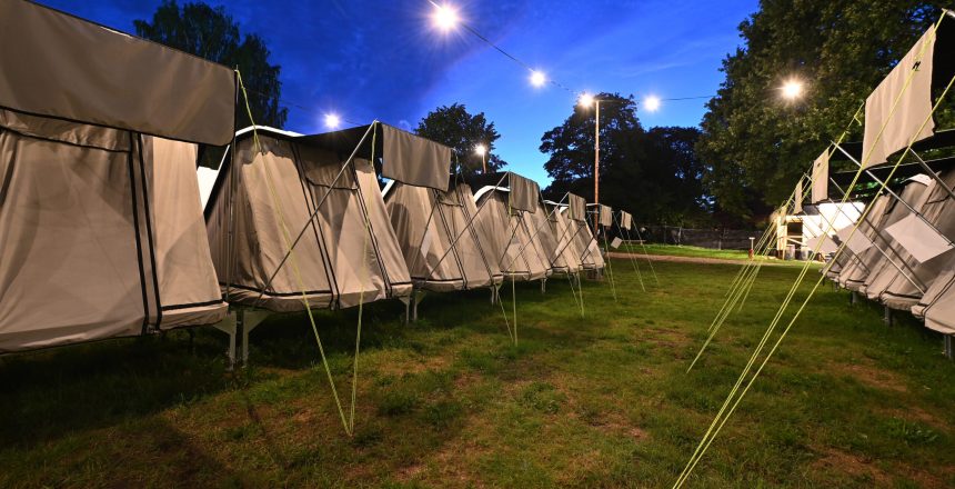 Rækker af opstillede telte på Lux Camp til Skive Festival under en blå aftenhimmel med lyskæder.